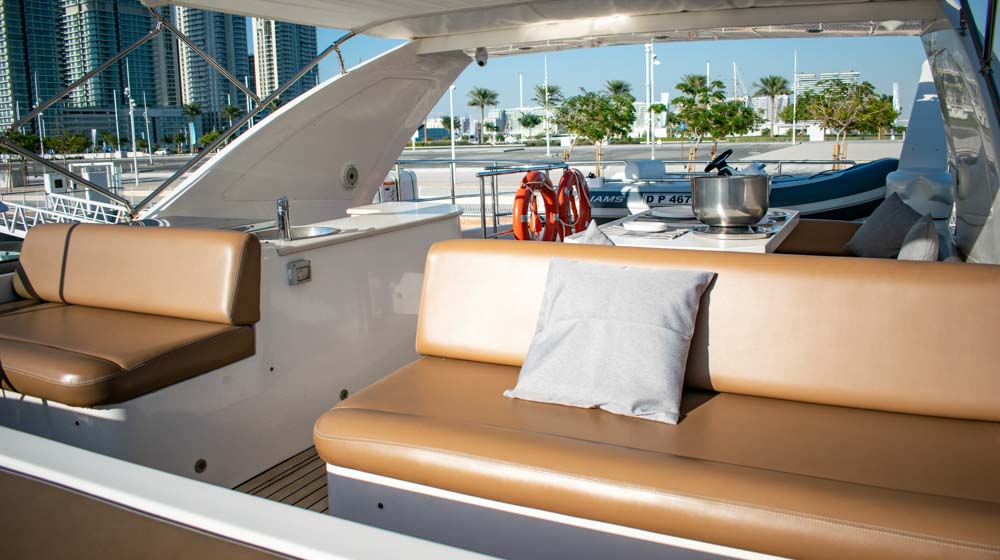 yacht docked in Dubai Harbour with flybridge featuring leather seating and dinette
